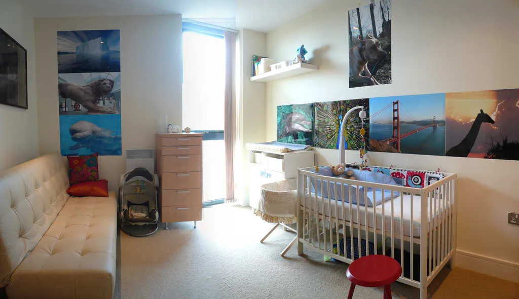 Chambre de bébé claire et vide, avec un lit à barreaux blanc, un couffin, une commode et une grande fenêtre